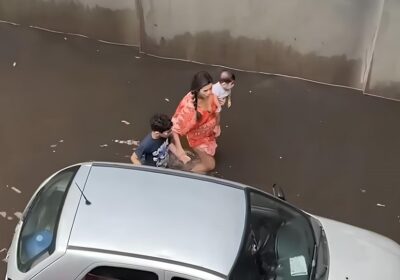 VÍDEOS: Mãe com filho no colo tenta empurrar carro em meio à chuva em Manaus